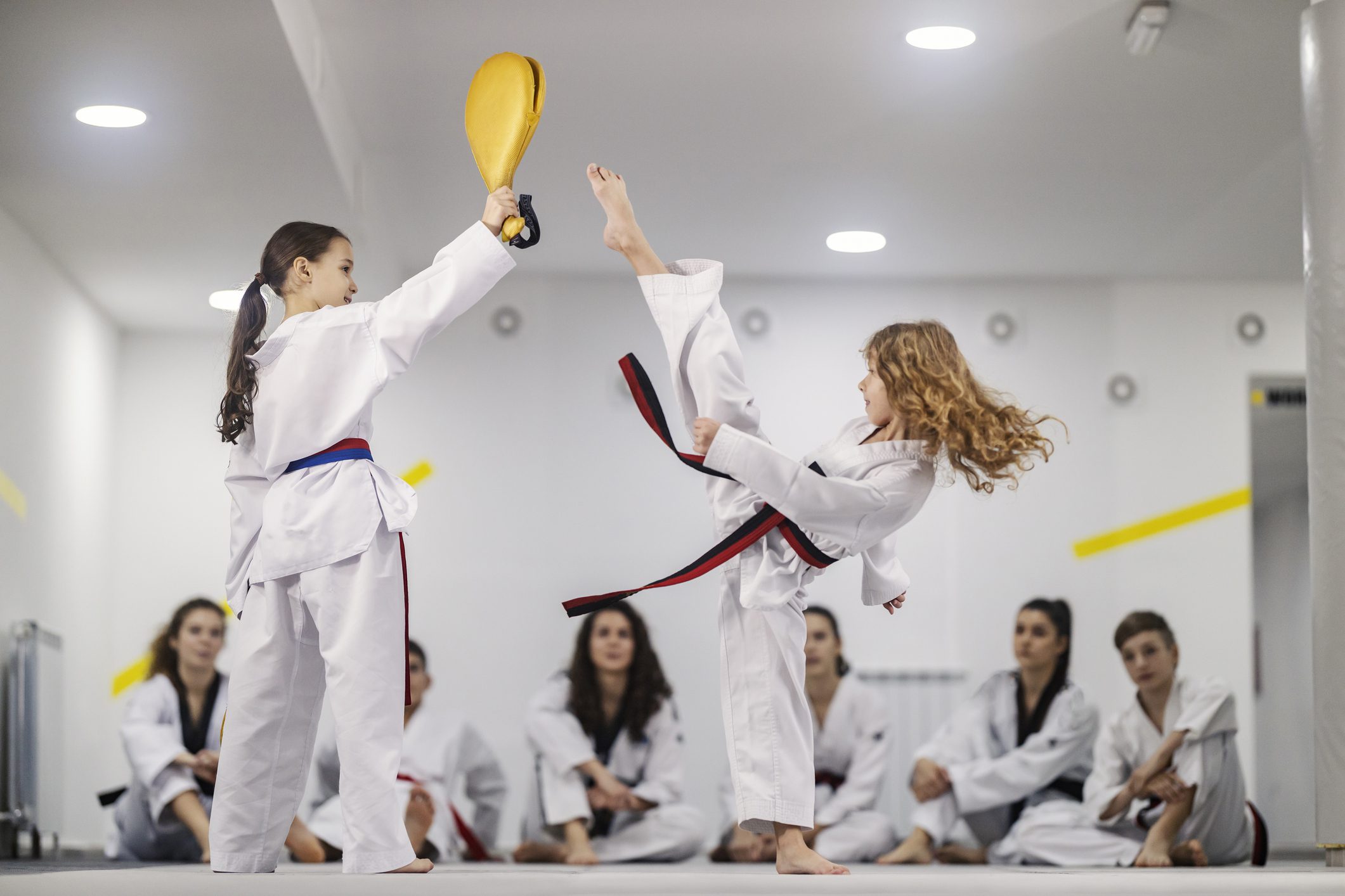 Two girls sparring in dojo