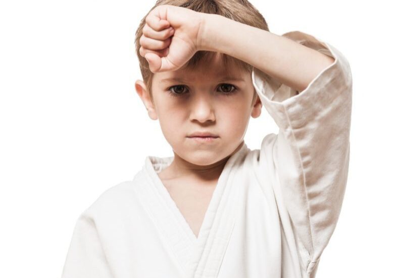 Boy practicing karate, inspiring message above.
